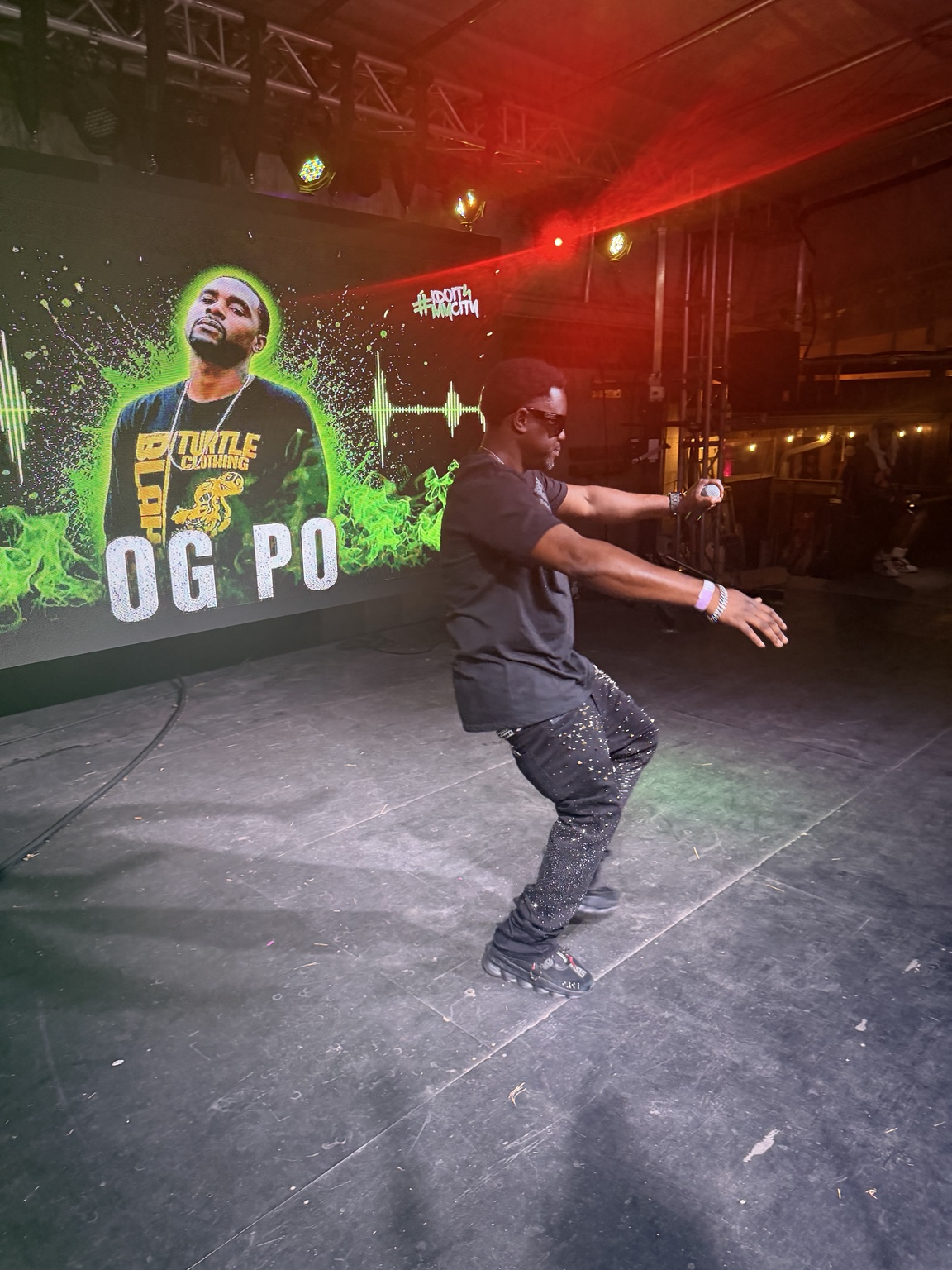 OG Po performs on the Heartwood Soundstage with his artist graphic on the LED screen.