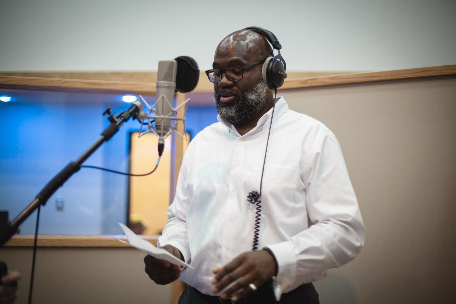 A professor recording a closing verse at the microphone during the studio recording experience