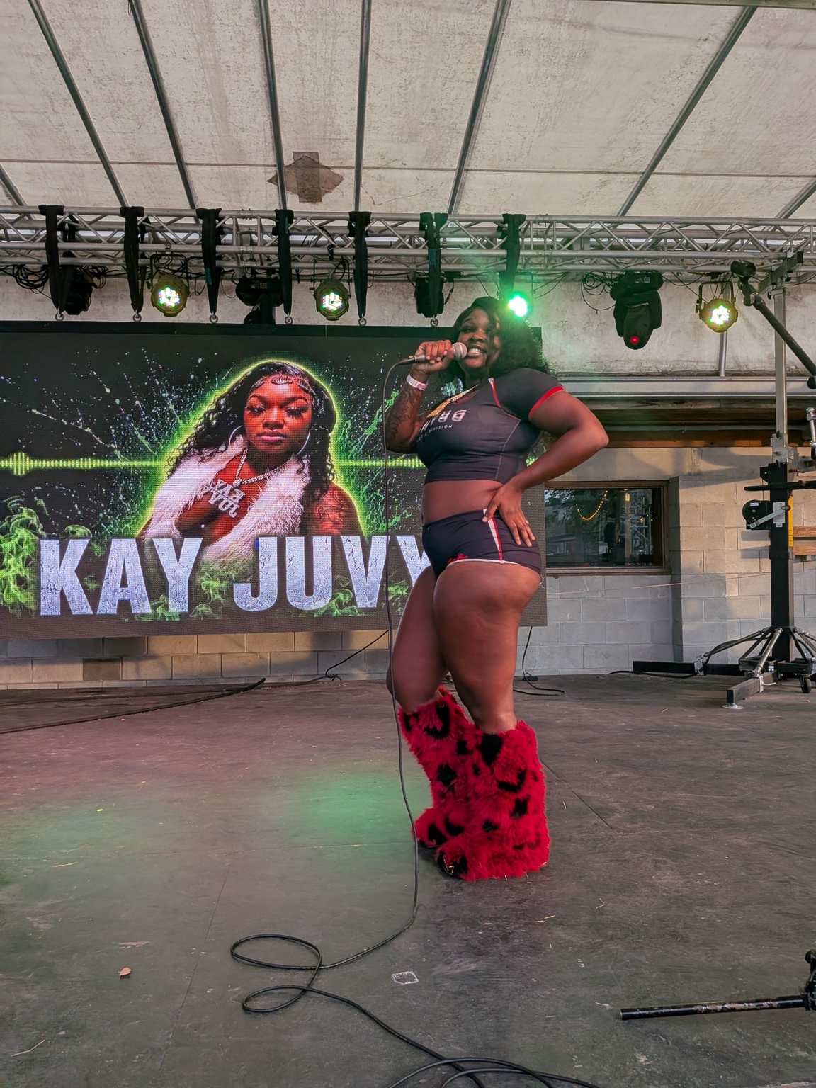 Kayjuvy performs on the Heartwood Soundstage with her artist graphic on the LED screen.