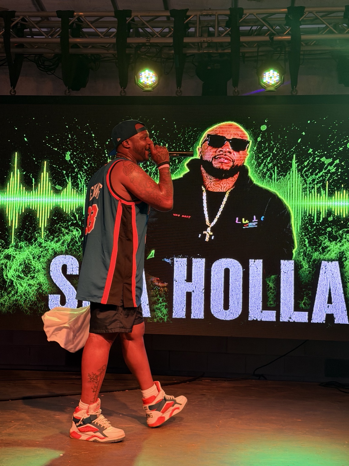 Sha Holla performs on the Heartwood Soundstage with his artist graphic on the LED screen.